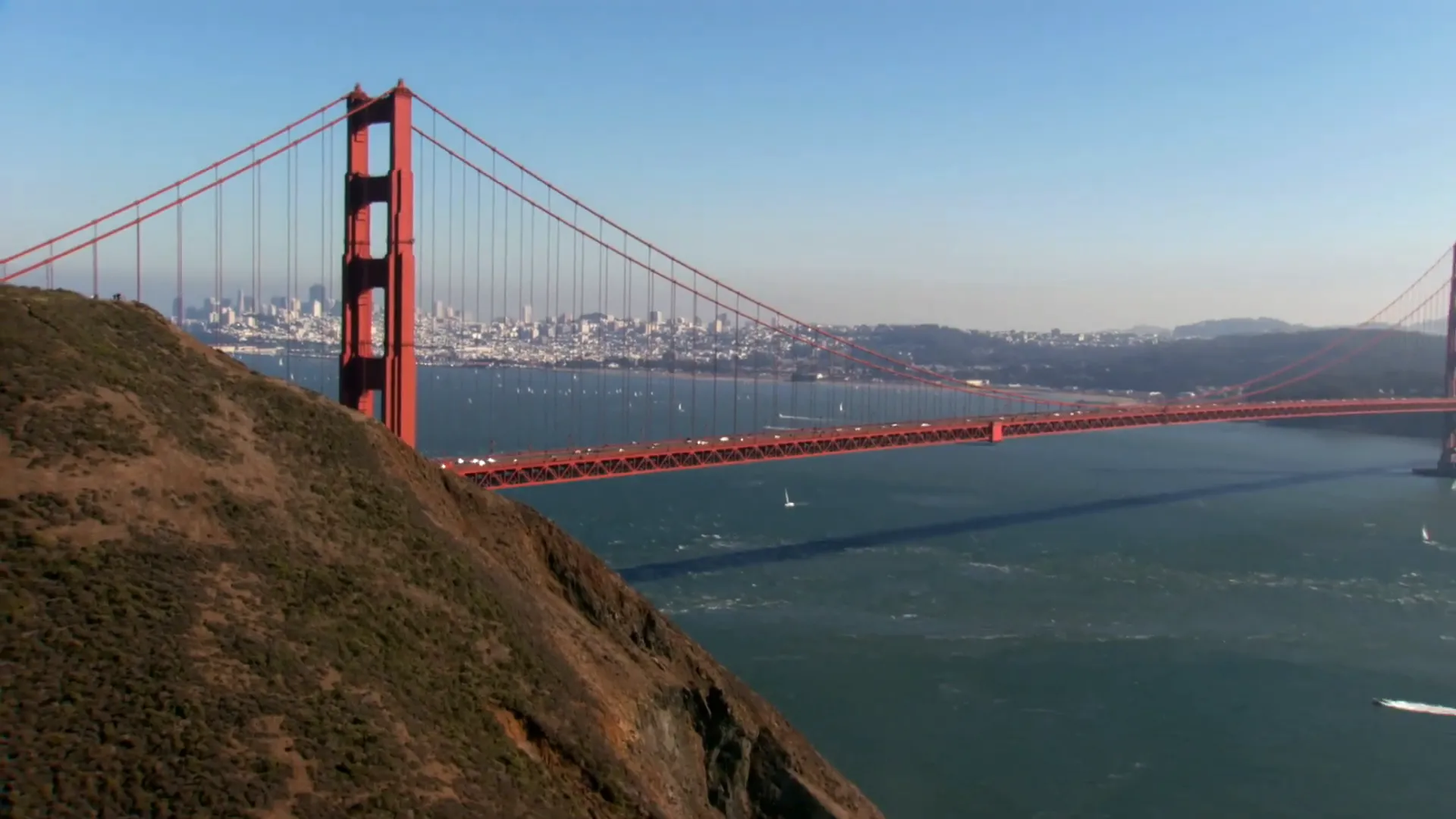 Golden Gate Bridge shrouded in fog with city skyline in background