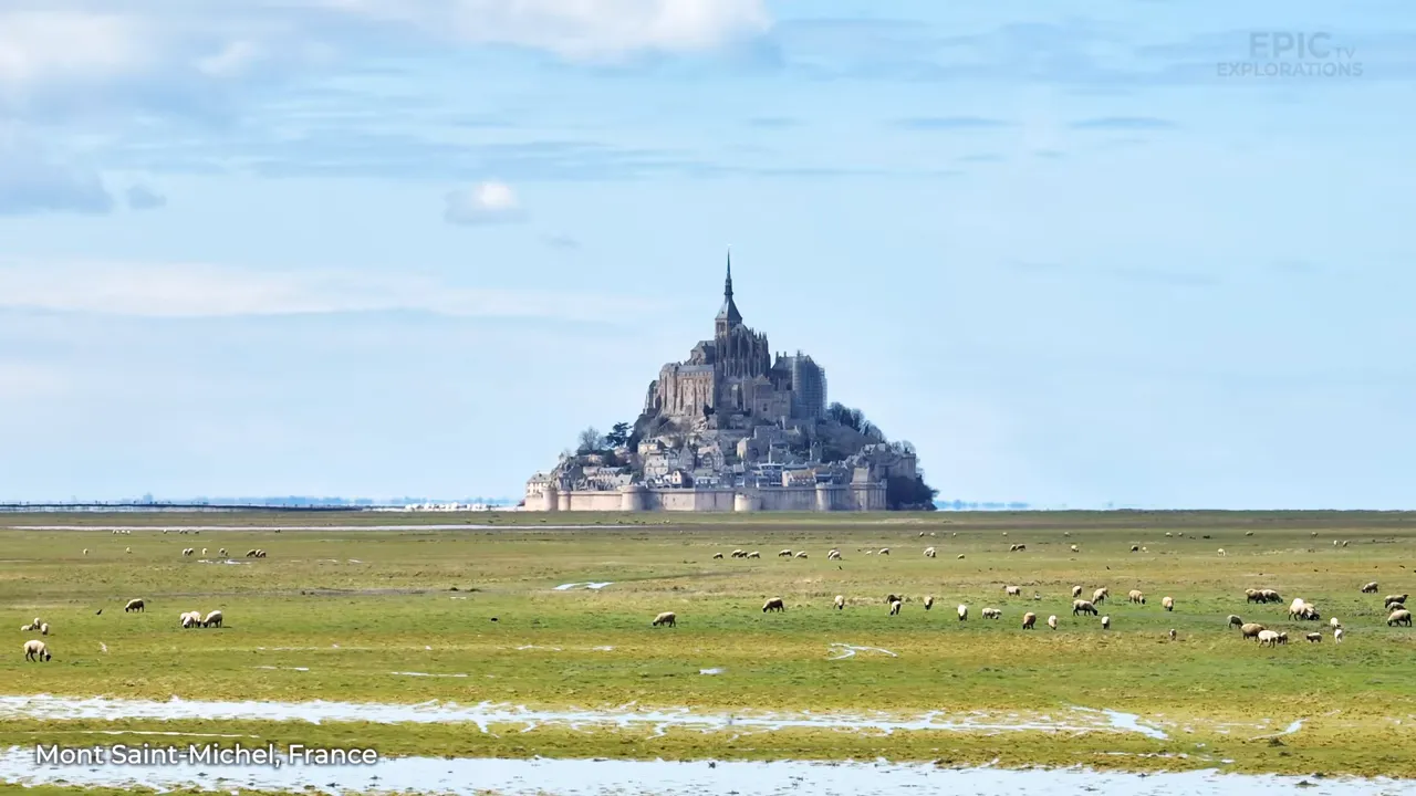 Mont Saint-Michel at low tide with surrounding wet sands reflecting sunlight