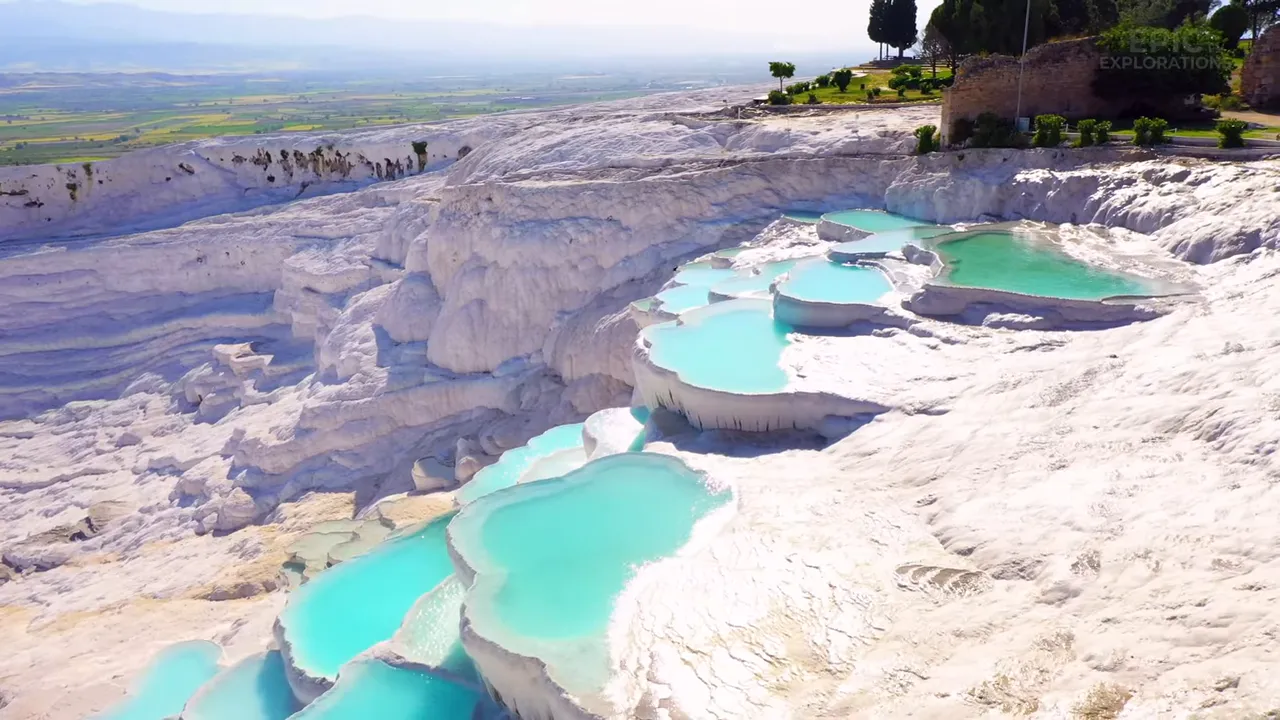 Terraced travertine pools of Pamukkale glowing white against blue skies