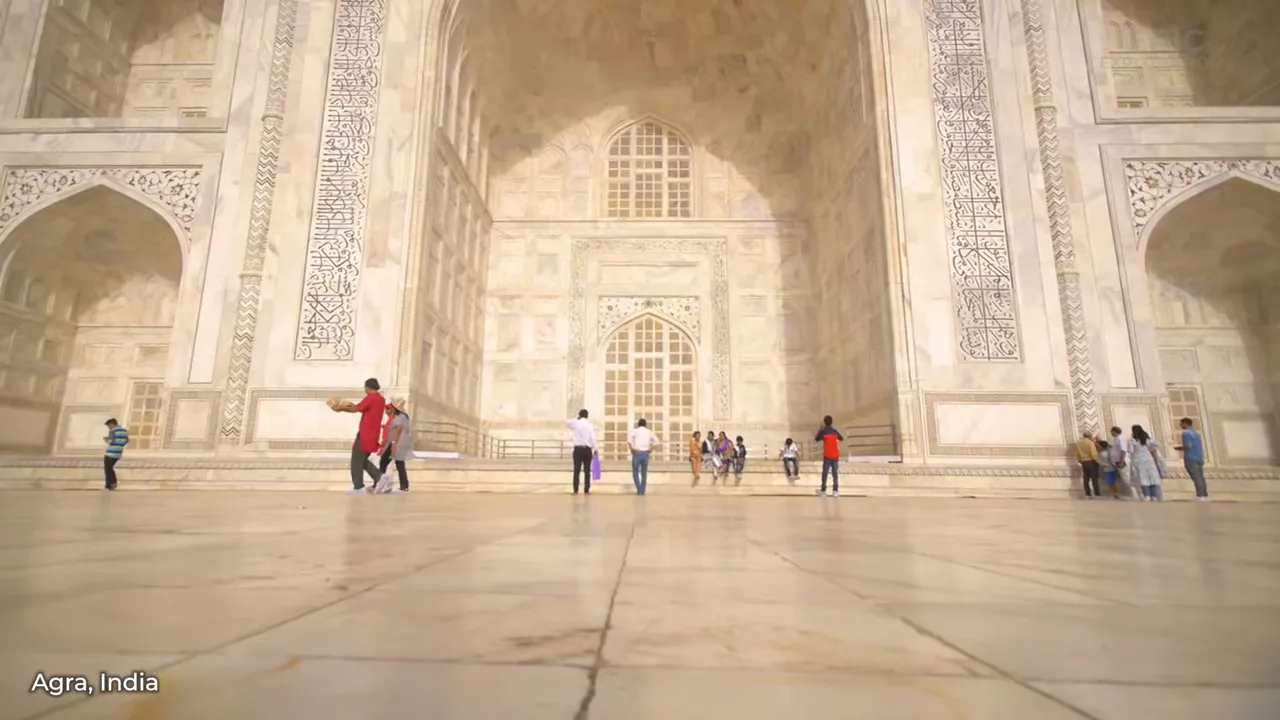 The Taj Mahal's white marble mausoleum reflecting on its pool at sunrise