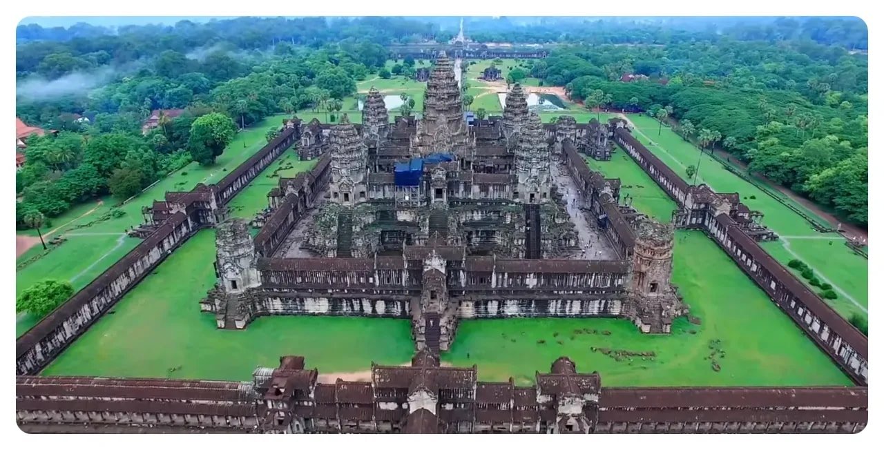 Aerial view of Angkor Wat temple complex showing the central towers, rectangular galleries, surrounding lawns and forest