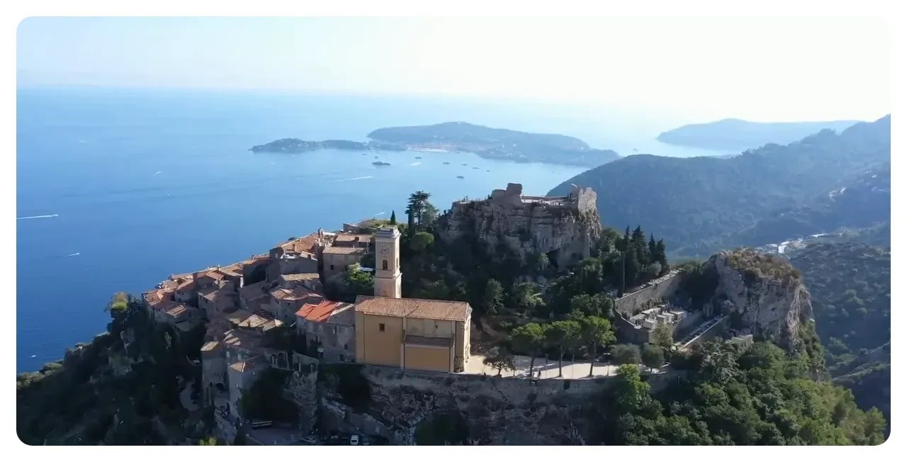Èze hilltop village with church tower and old fortifications overlooking the Mediterranean and distant islands