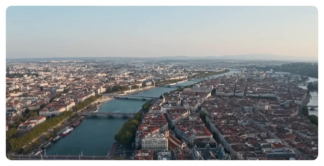Wide aerial view of Lyon with the Saône River, bridges and dense city blocks