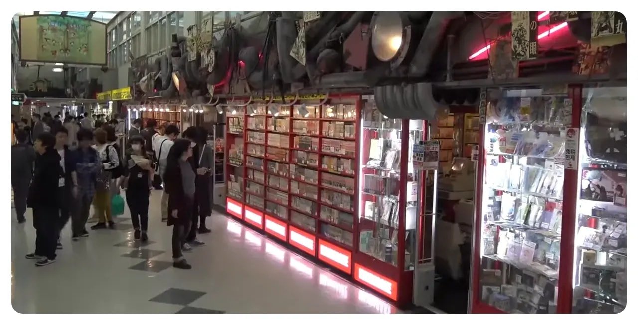 Interior corridor of Nakano Broadway with display cases, shelves of items and people browsing
