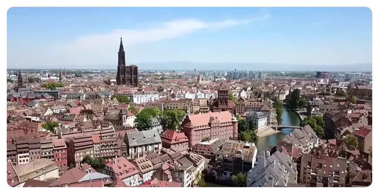Aerial panorama of Strasbourg showing the cathedral spire, canals and historic red-tiled roofs