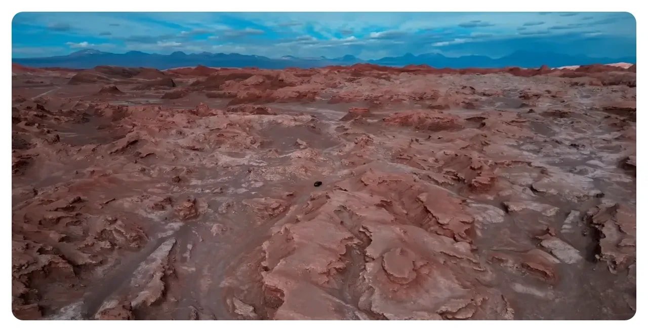 High-resolution aerial shot of reddish, sculpted rock formations and plateaus in Valle de la Luna, Atacama Desert